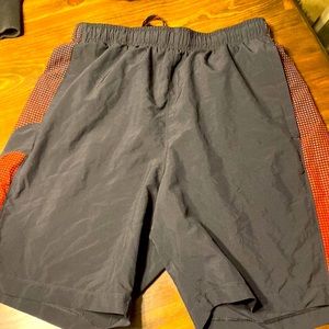 Black and red under armor shorts for training sports.